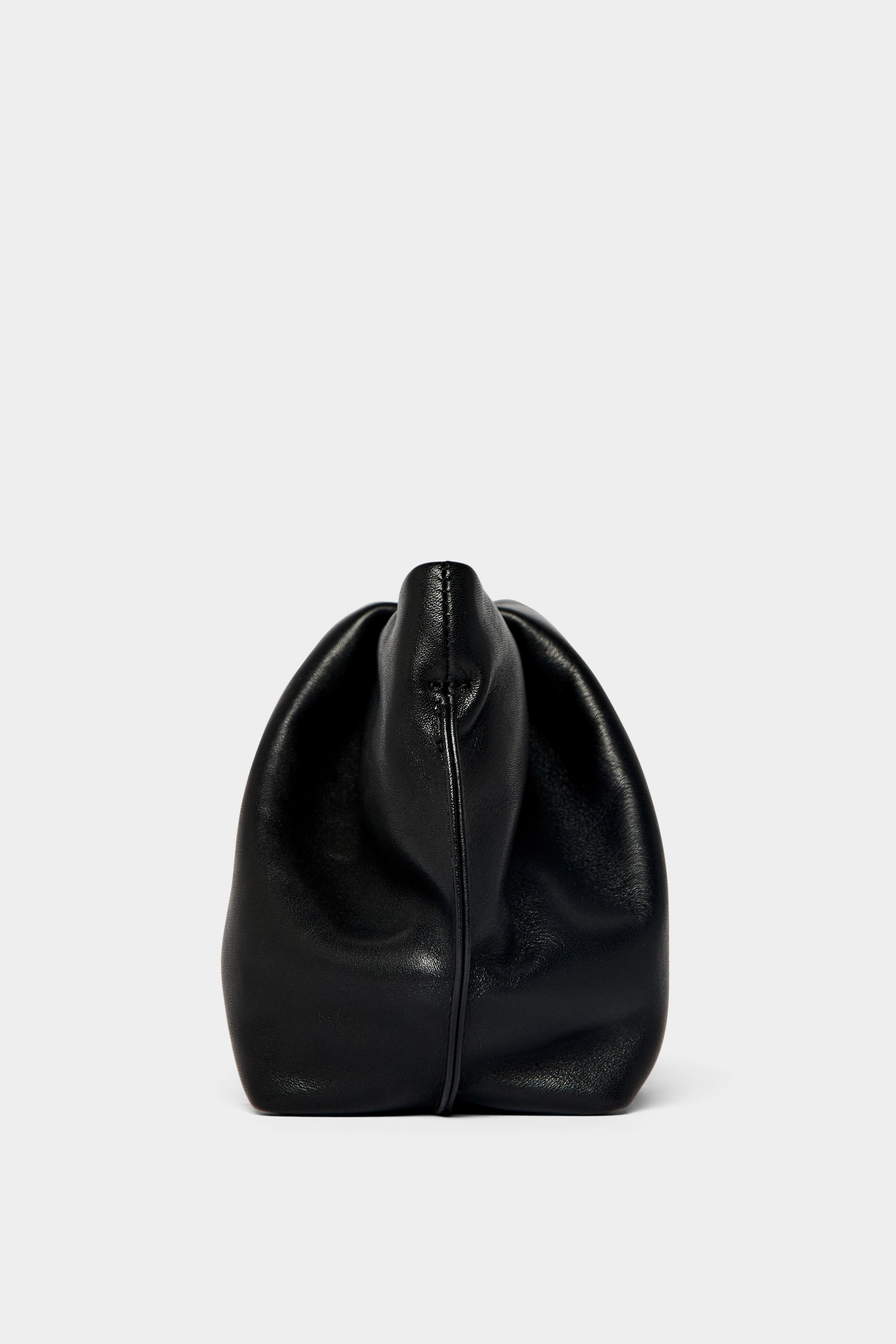 A side angle of the Fold clutch purse features delicate hand stitching of the handbag.