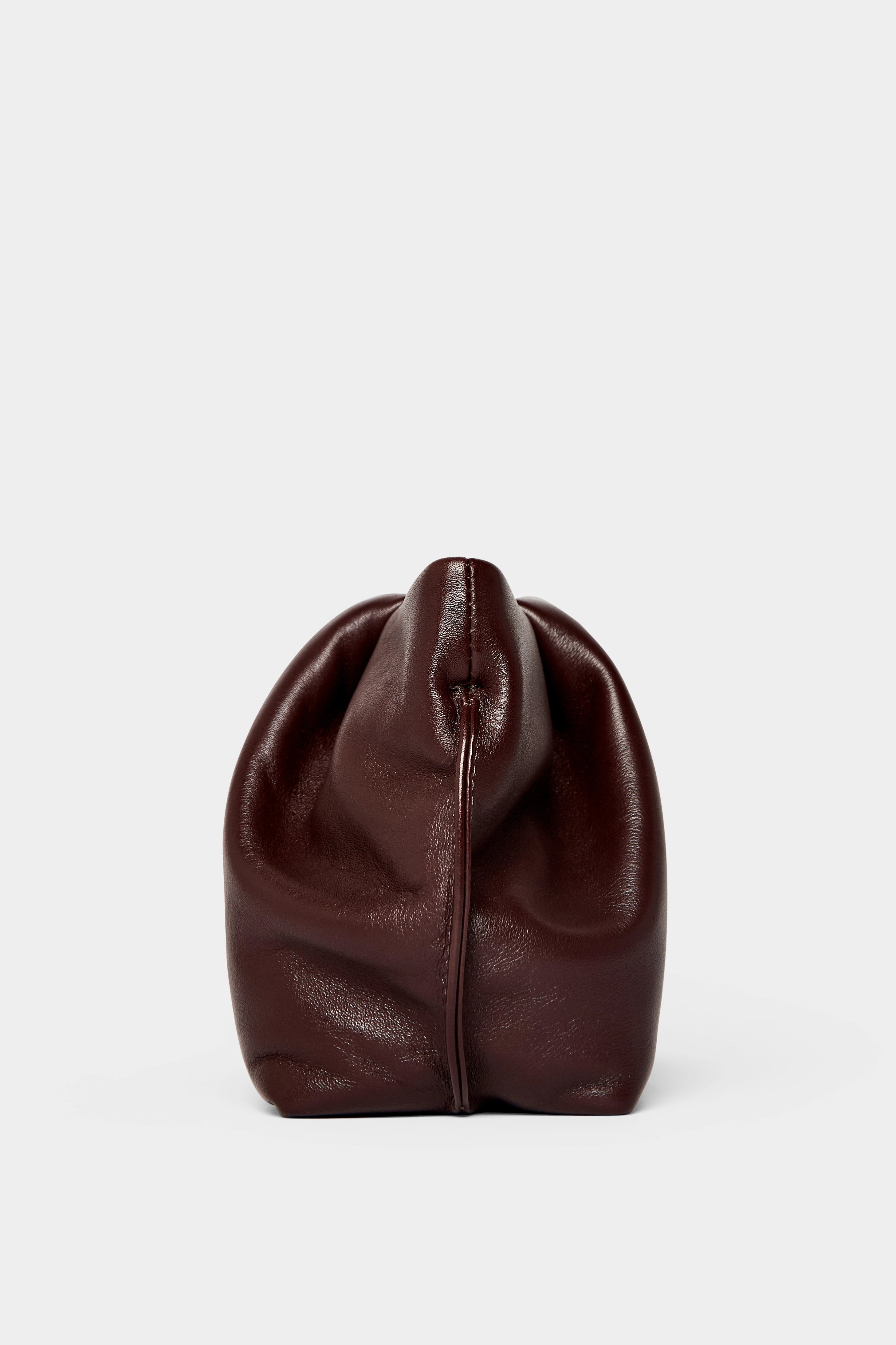 A side angle of the Fold clutch purse features delicate hand stitching of the handbag.