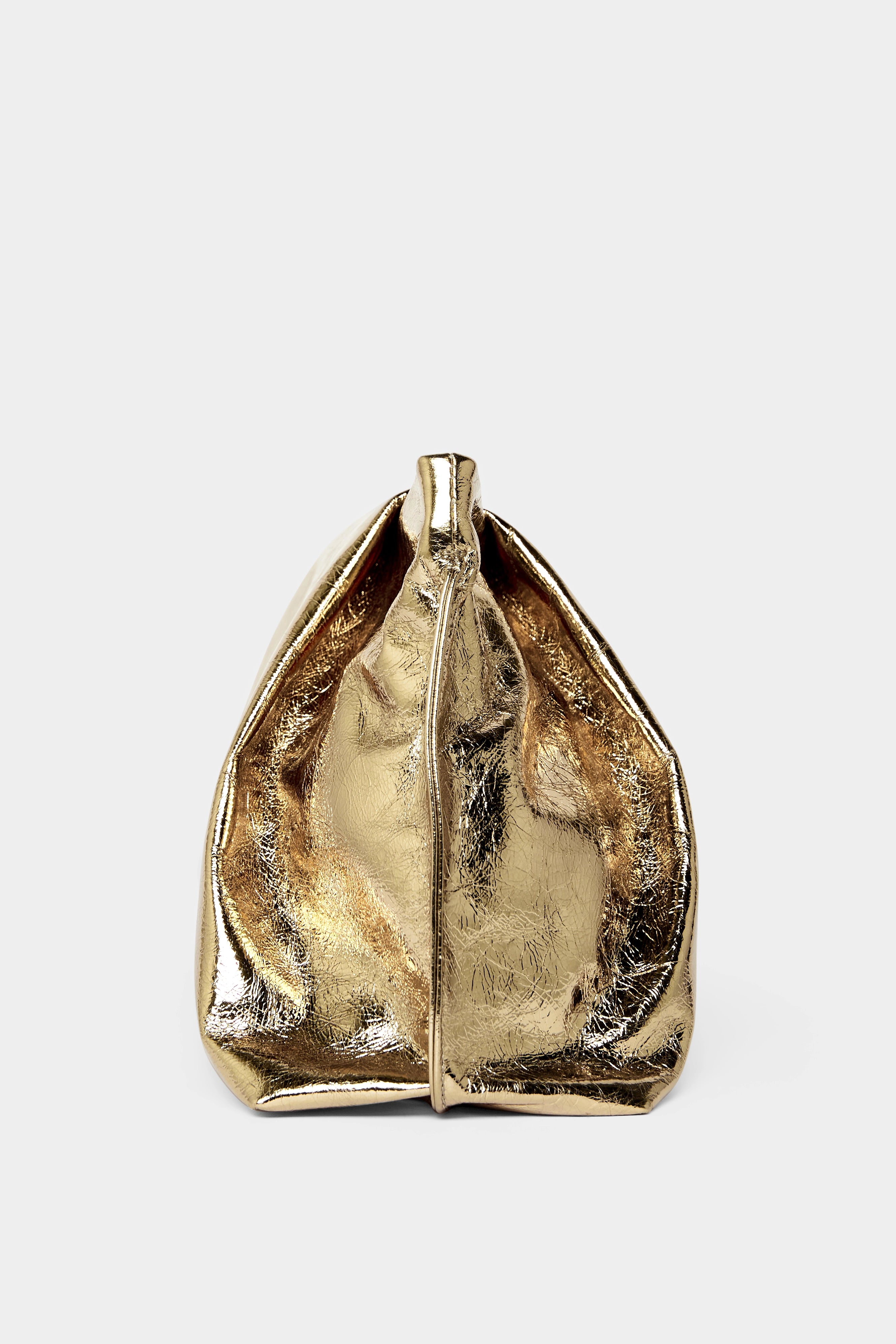 A side angle of the Fold clutch purse features delicate hand stitching of the handbag.