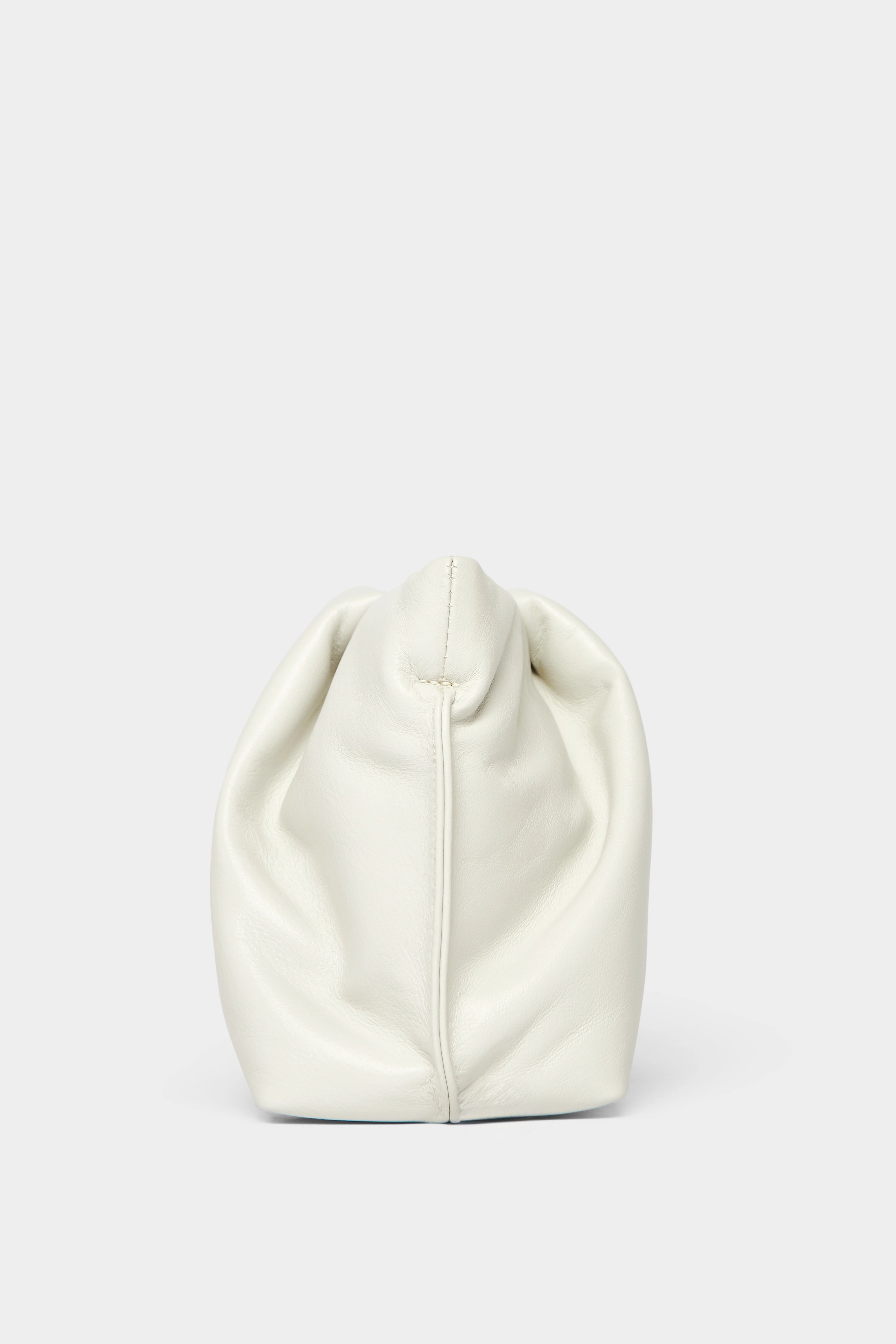 A side angle of the Fold mini clutch purse features delicate hand stitching of the handbag.