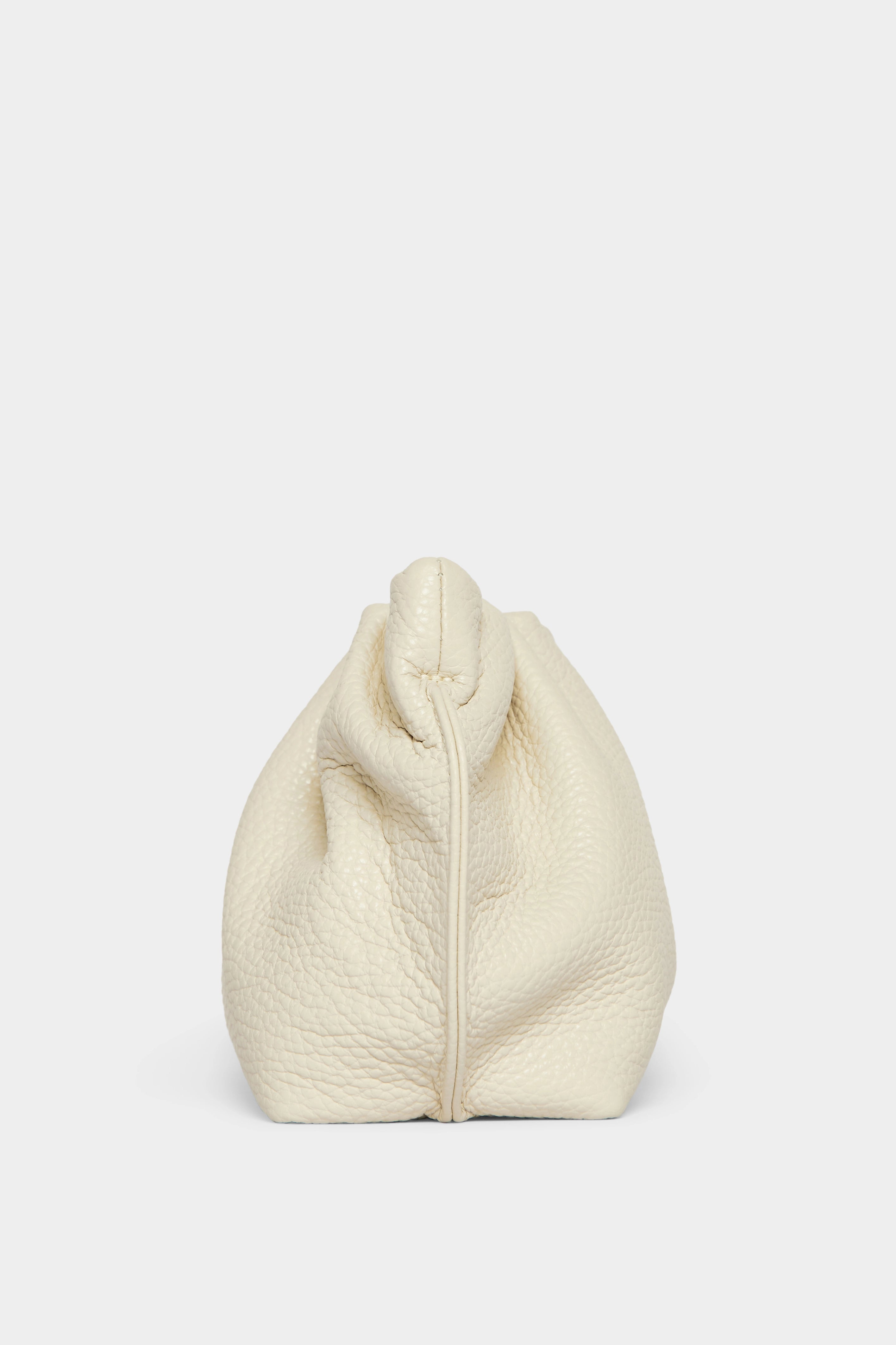 A side angle of the mini Puffa clutch purse featuring a delicate hand stitching of the mini bag's sides.