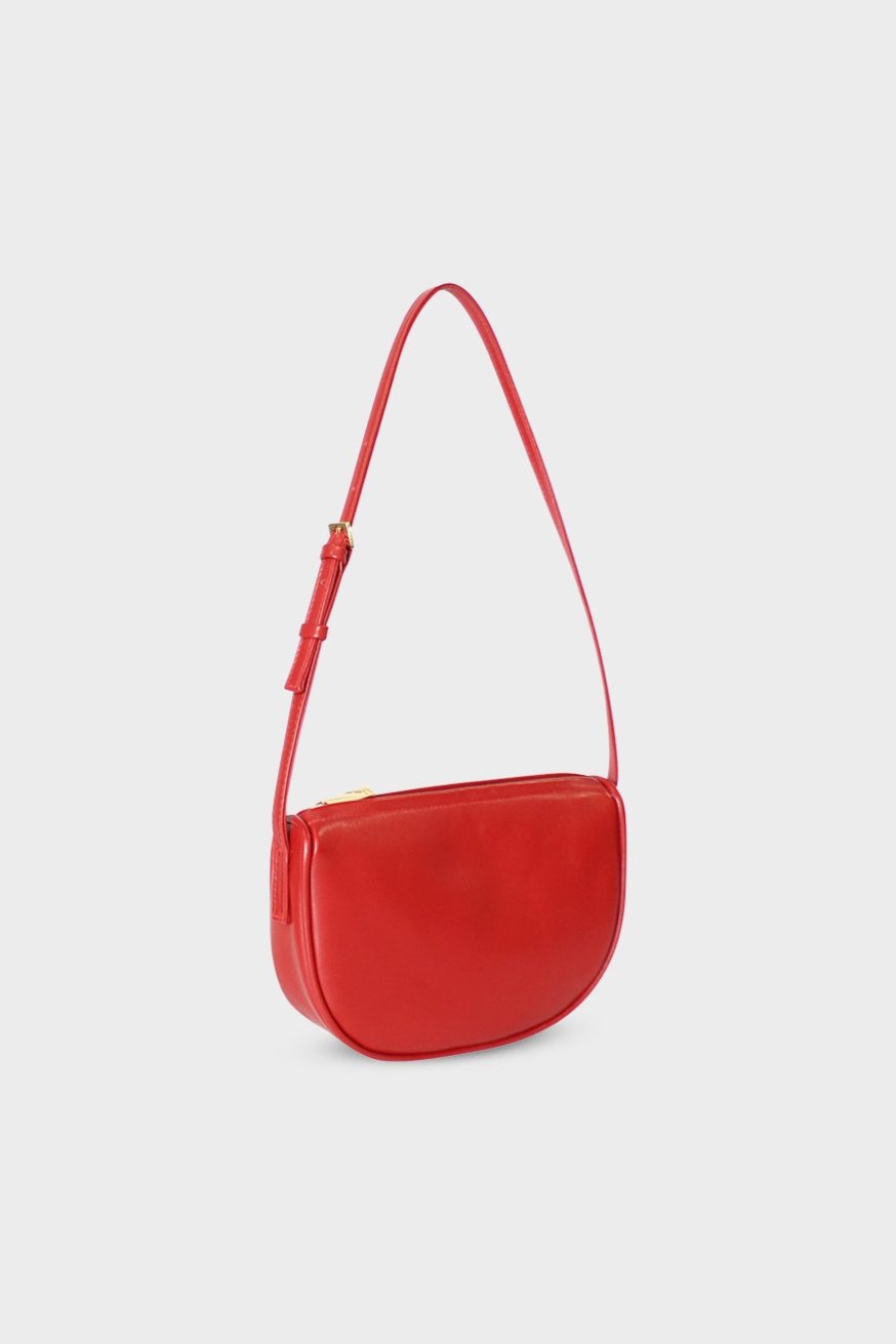 A side image of a shoulder bag in the color red. The mini bag follows a saddle like design with a slim body. The bag is called Mini Saddle Shoulder Bag in Smooth Red.