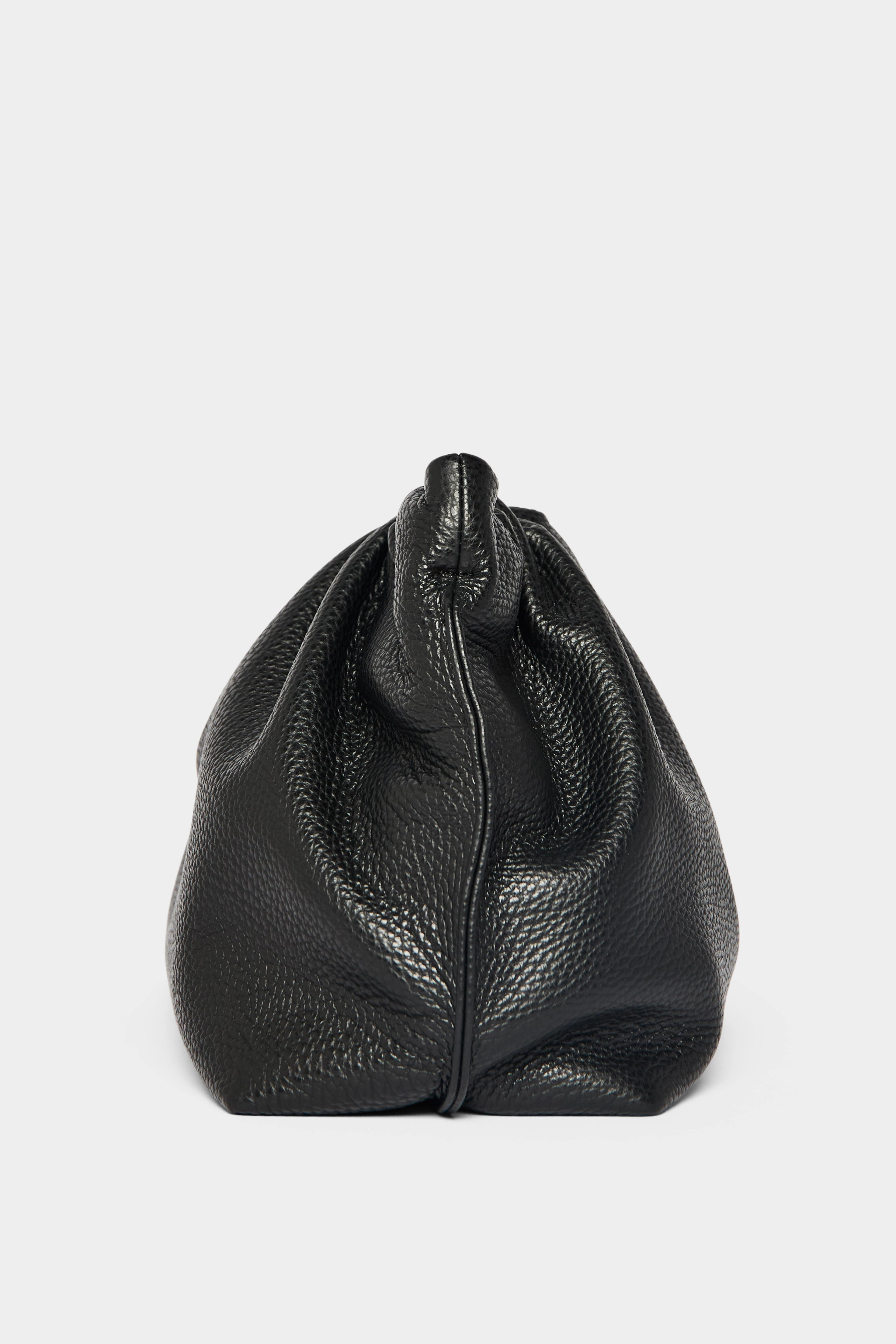 A side angle of the Puffa clutch purse featuring a delicate hand stitching of the mini bag's sides.