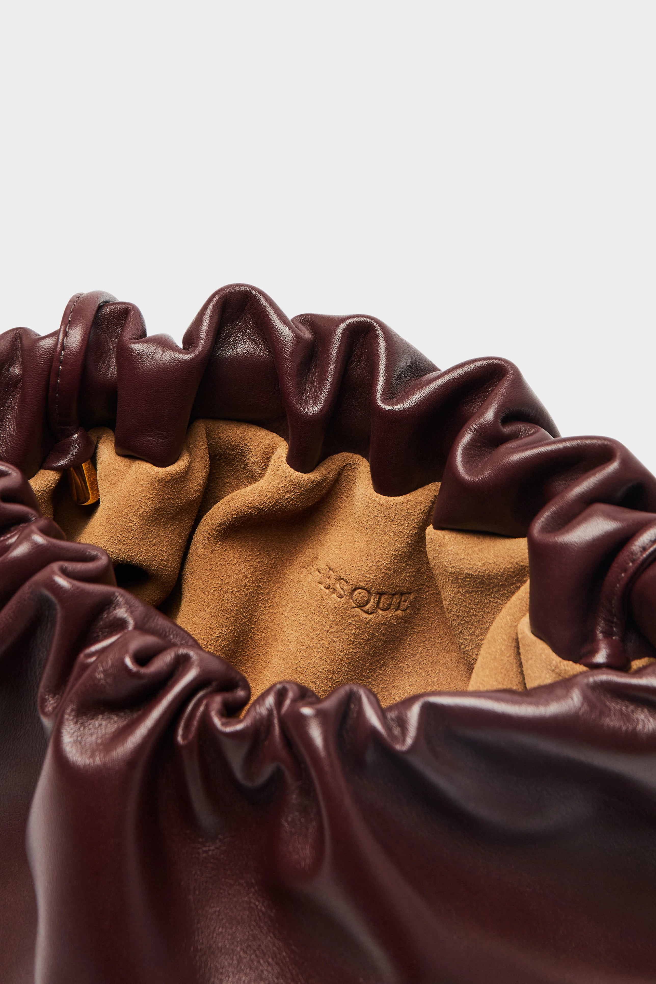 Puffa clutch crossbody bag has a suede interior lining with an A-esque logo stamped in the middle.