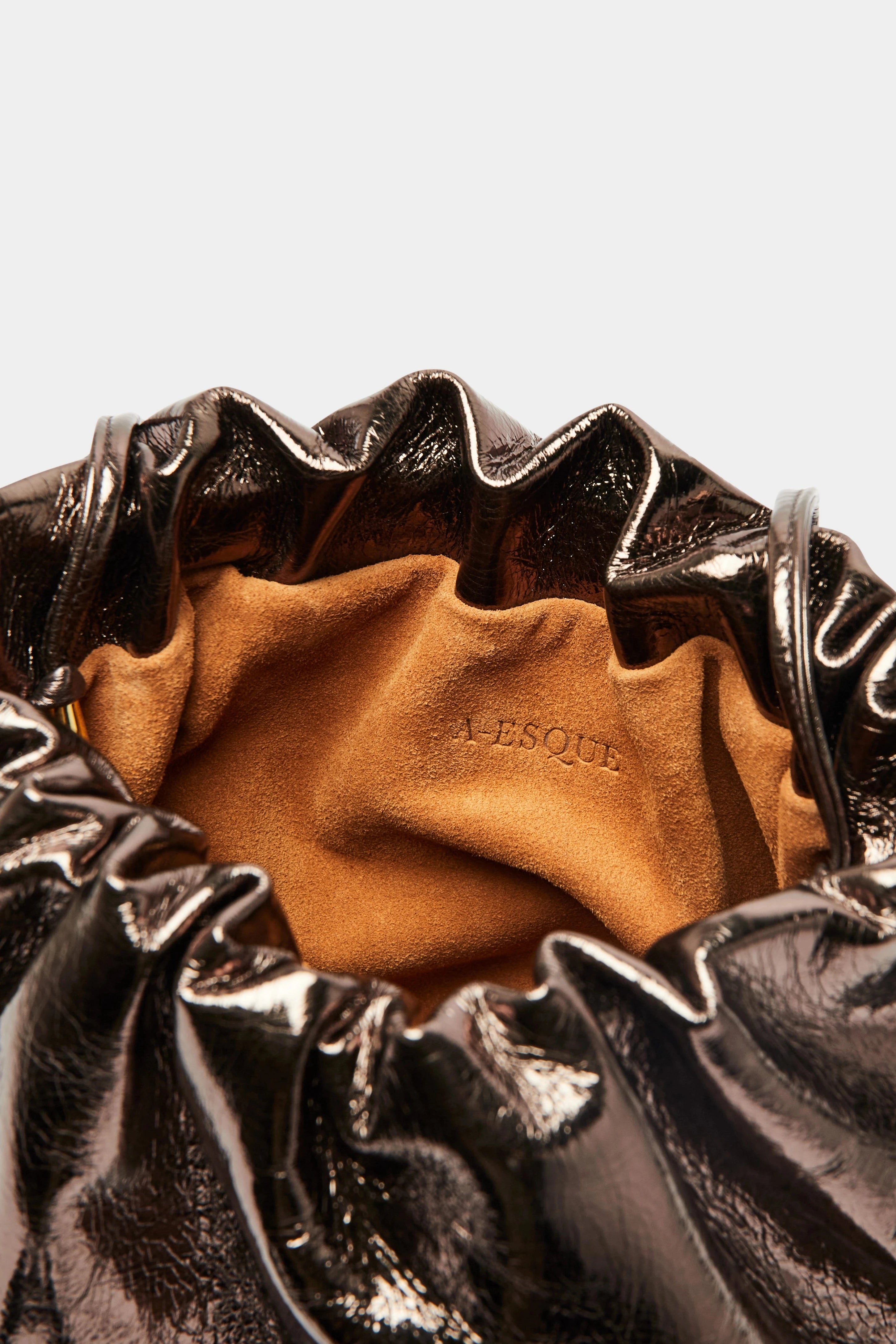 Puffa clutch crossbody bag has a suede interior lining with an A-esque logo stamped in the middle.