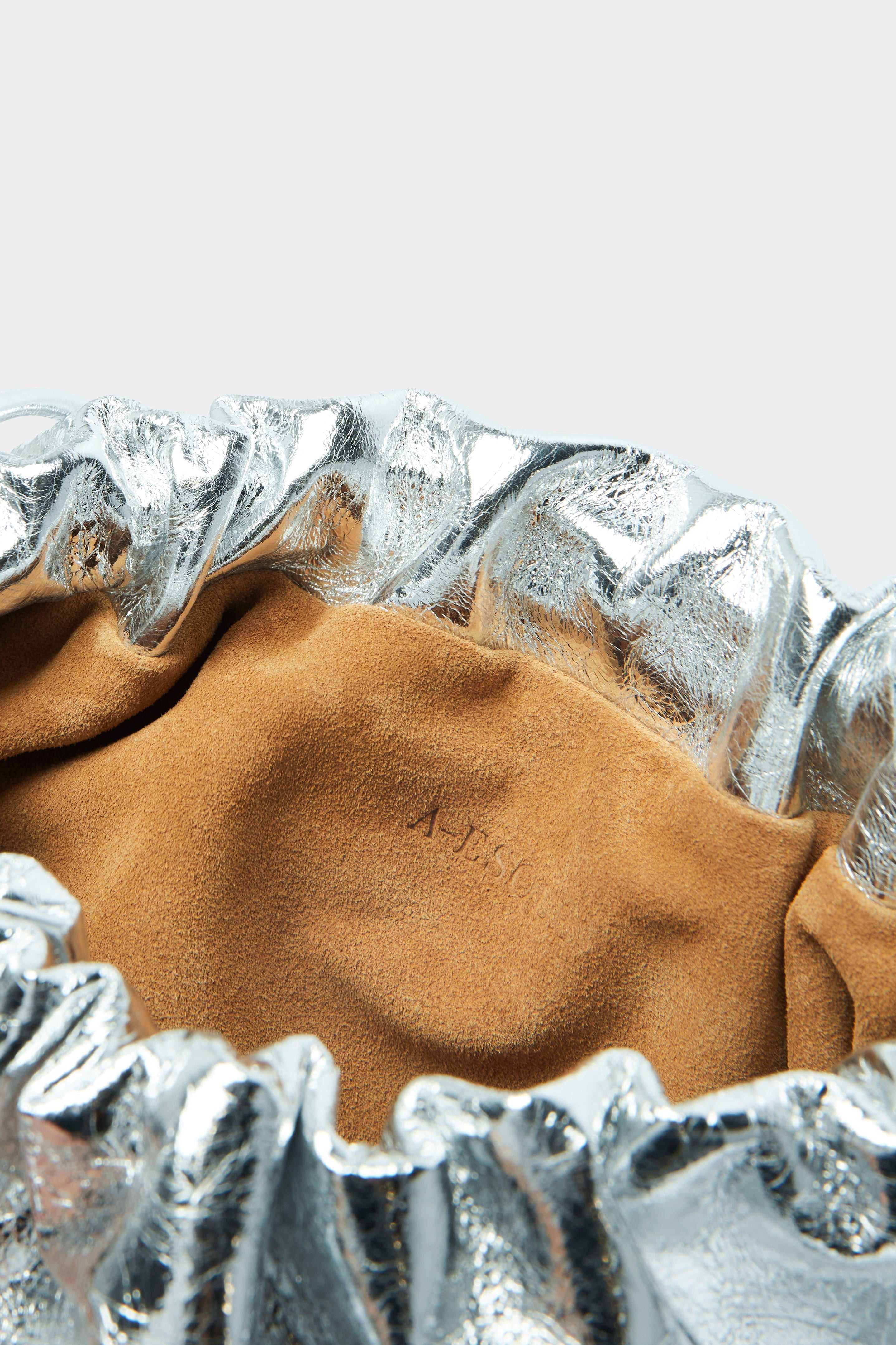 Puffa clutch crossbody bag has a suede interior lining with an A-esque logo stamped in the middle.