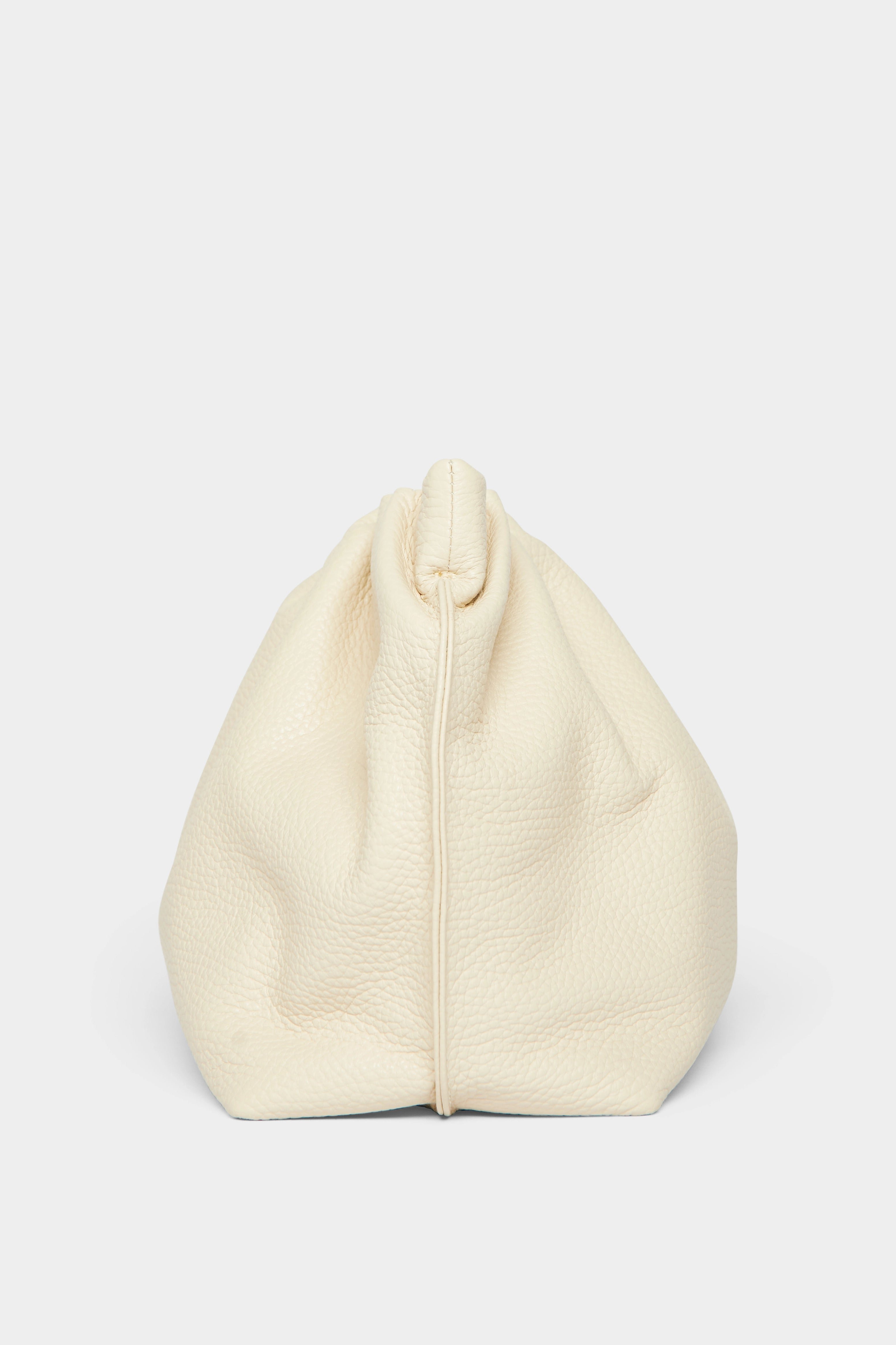 A side angle of the Puffa clutch purse featuring a delicate hand stitching of the mini bag's sides.