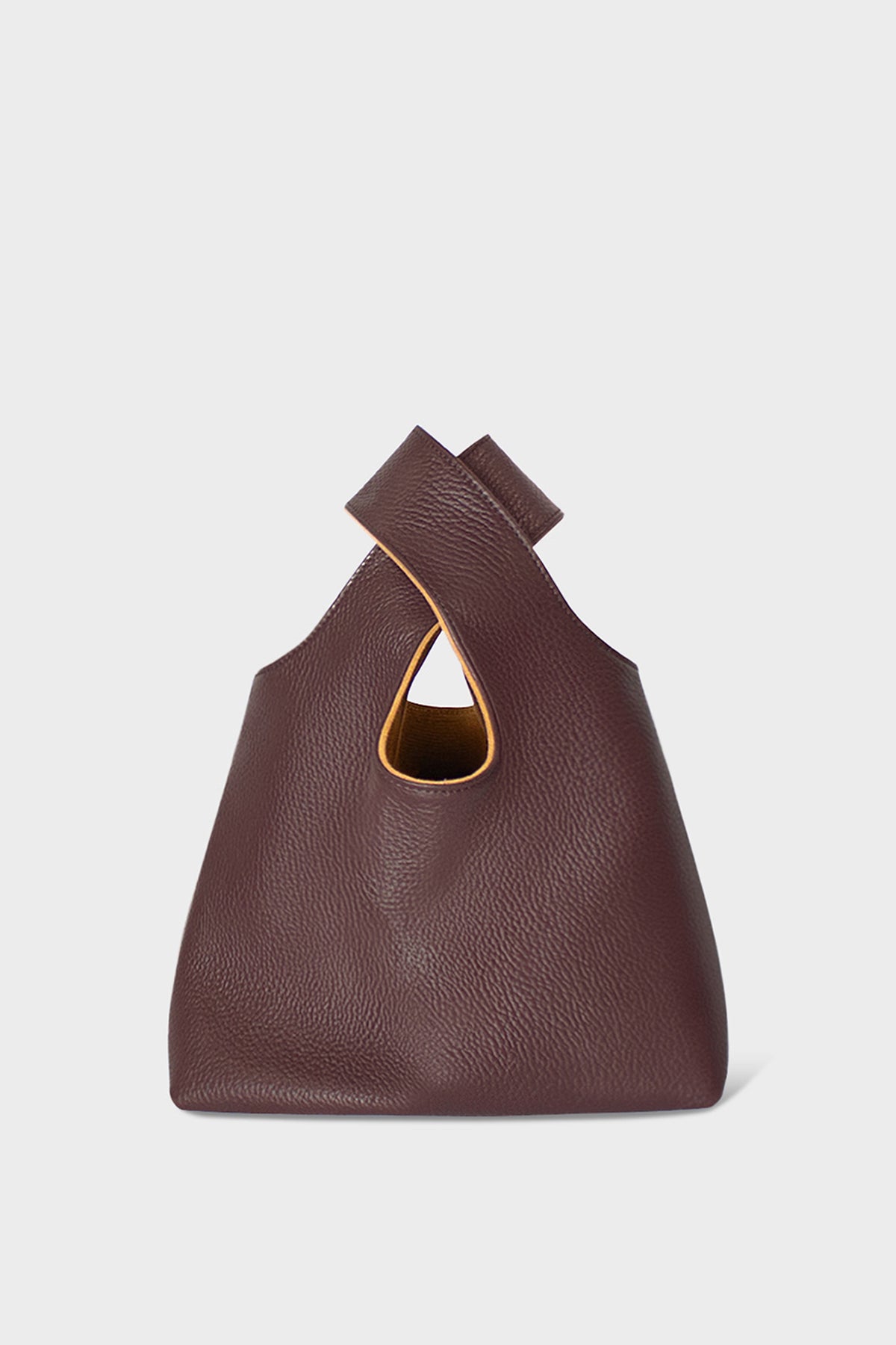 A small burgundy handbag made of fine Italian grain leather. This mini bag is suited to carry as a clutch for casual events.