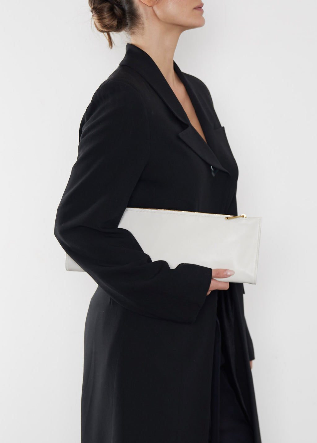 A woman carrying the red slimline clutch pouch. The clutch is folded and looks like a long wallet. It's suited as a party clutch or a casual pouch or purse.