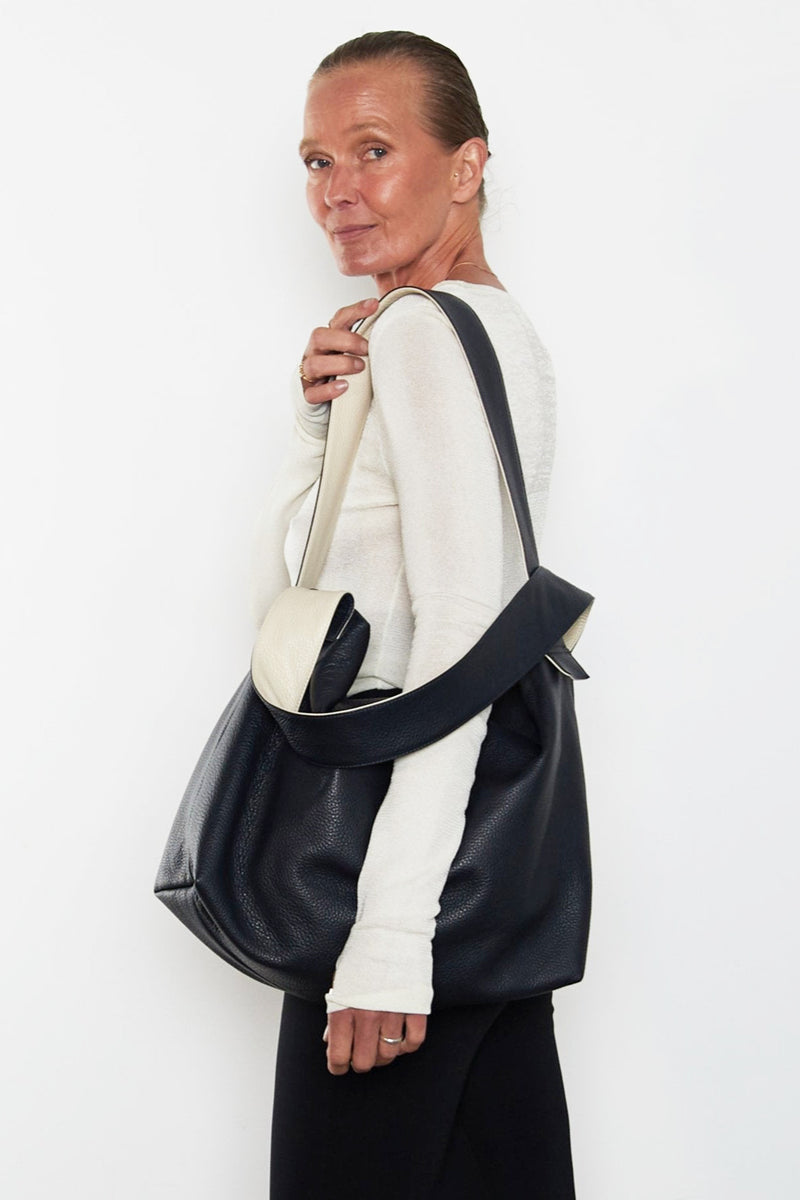 An image of a woman carrying the Big Day shoulder bag. The bag’s large capacity suits as a travel bag or an everyday large work bag.