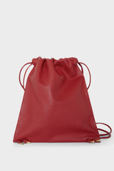 A red backpack with a draw closure. The backpack has a versatile design and can be worn as a shoulder bag or crossbody bag for men and women.