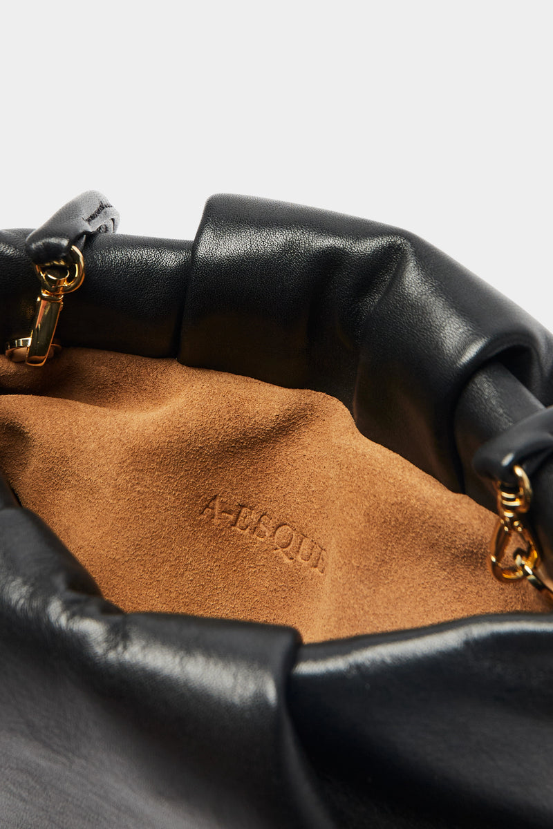 A close up image of the inside suede lining of the Fold mini clutch bag with A-sque logo stamped in the middle. 