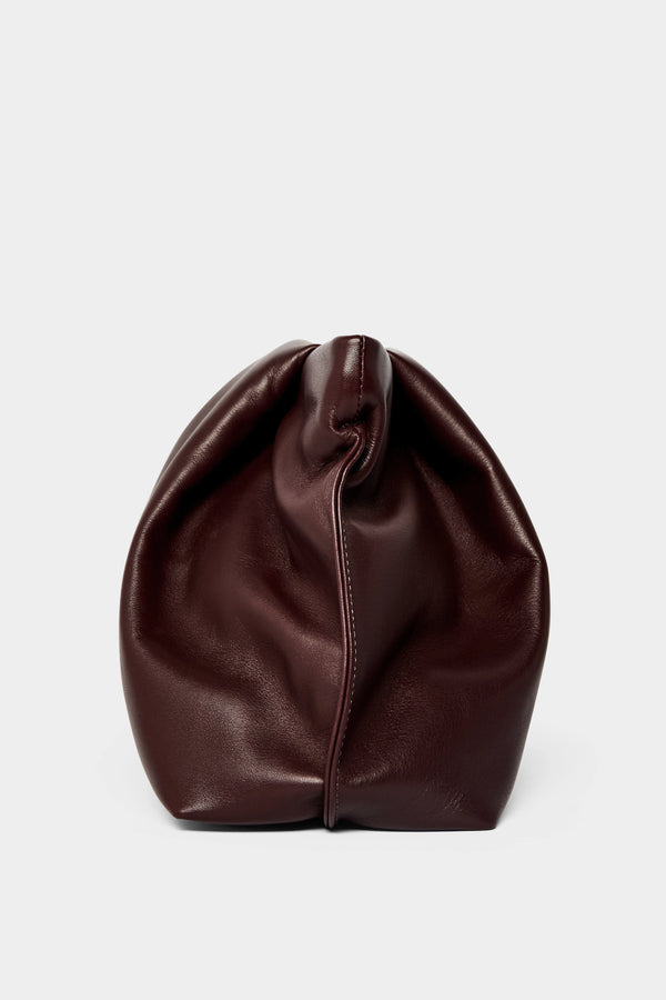 A side angle of the Fold clutch purse features delicate hand stitching of the handbag. 