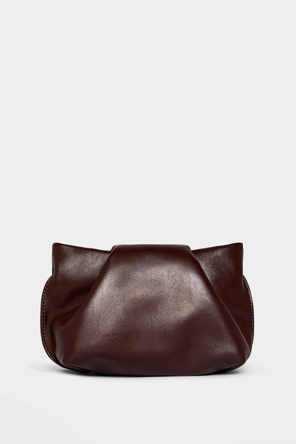 A burgundy mini clutch bag made of smooth Italian leather. This mini bag has a removable strap and can also be worn as a shoulder bag. 