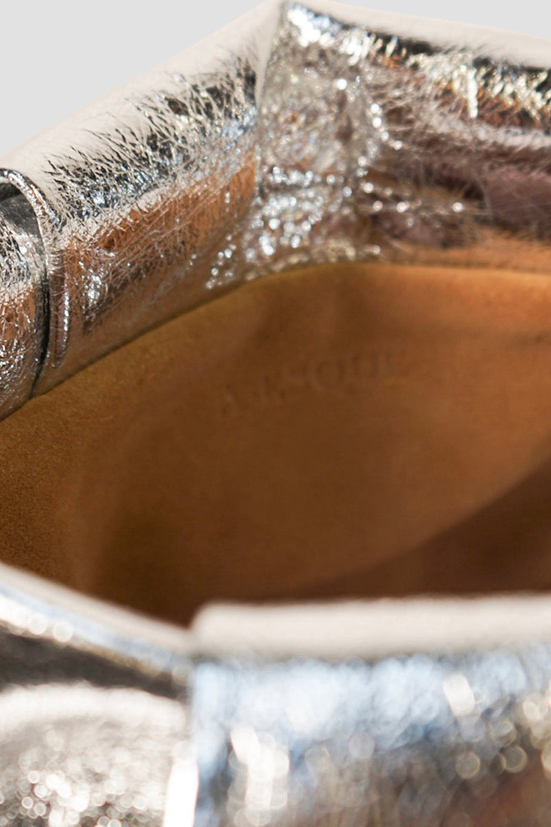 A close-up image of the inside brown suede lining of Fold clutch bag with A-sque logo stamped in the middle.