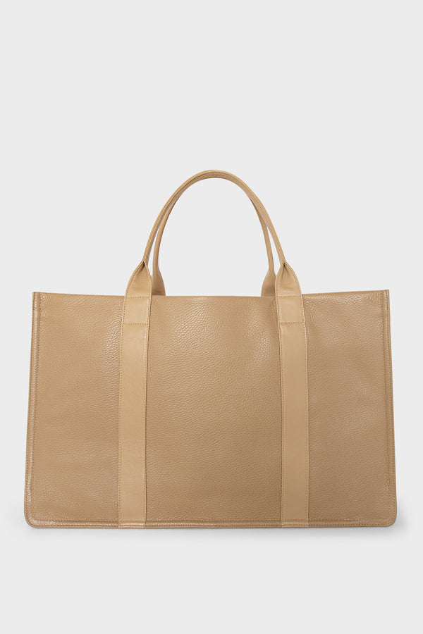 A large beige tote bag with a rectangular body and a magnetic closure. The bag has 2 handles to be carried handheld or as a shoulder bag.