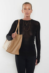 An image of a woman wearing the Grocer tote as a shoulder bag. 