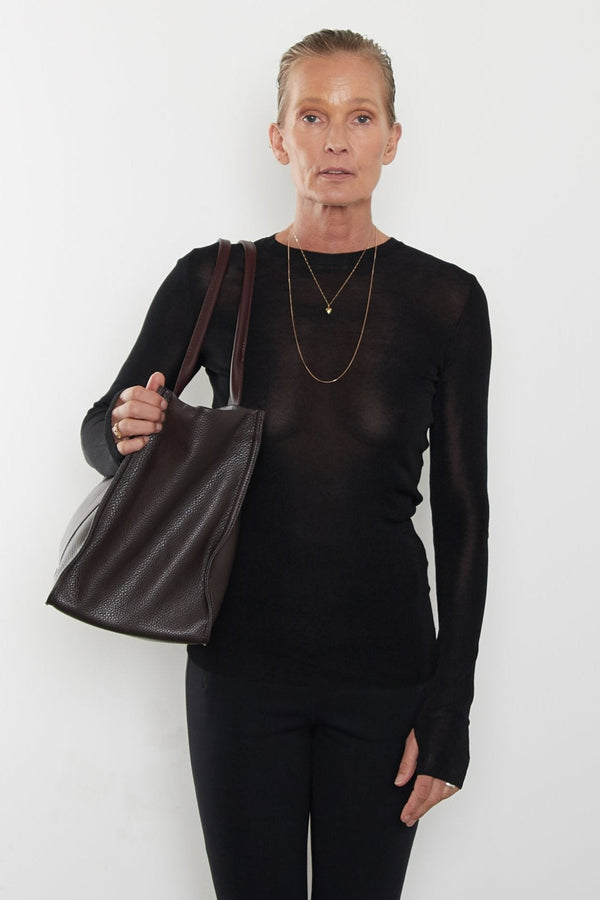 An image of a woman wearing the Grocer tote as a shoulder bag.