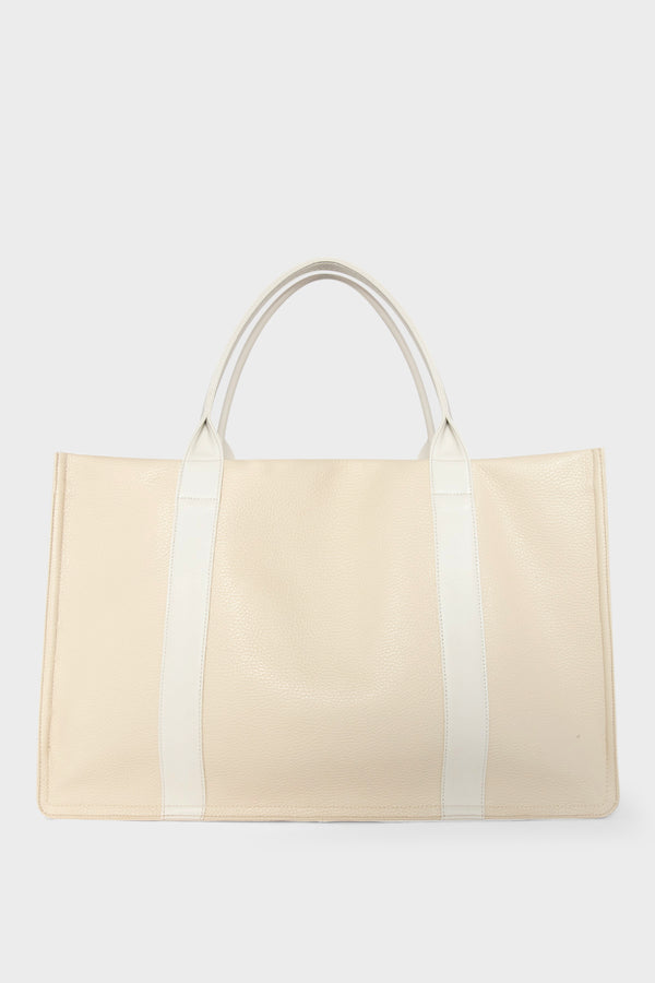 A large white tote bag with a rectangular body. It has a wide top with a magnetic closure. The bag has 2 handles to be carried handheld or as a shoulder bag.