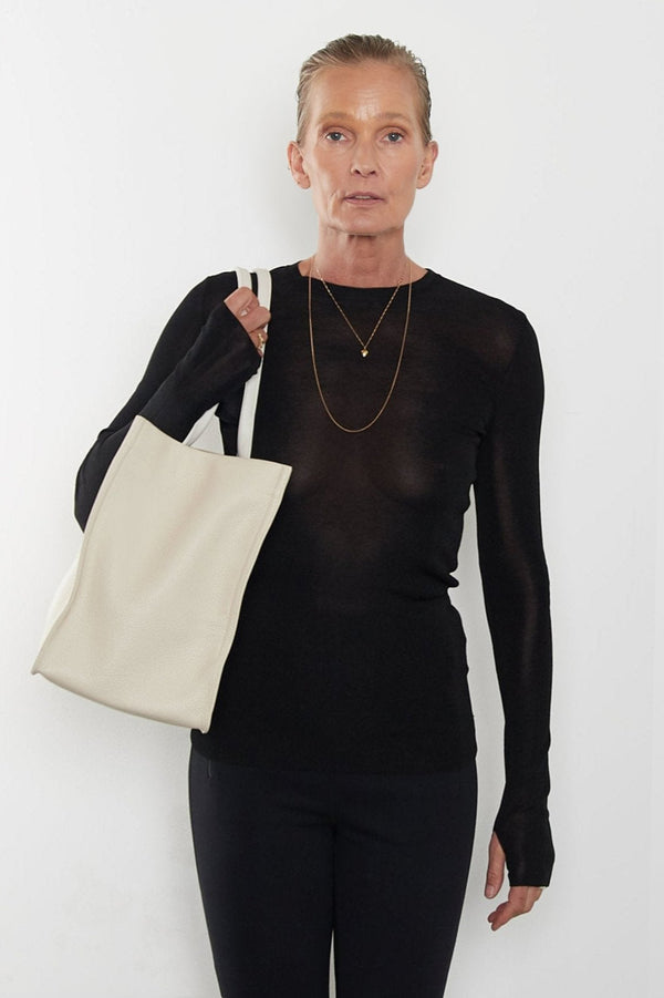 An image of a woman wearing the Grocer tote as a shoulder bag.