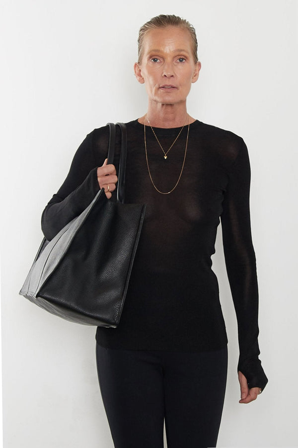 An image of a woman wearing the Grocer tote as a shoulder bag.