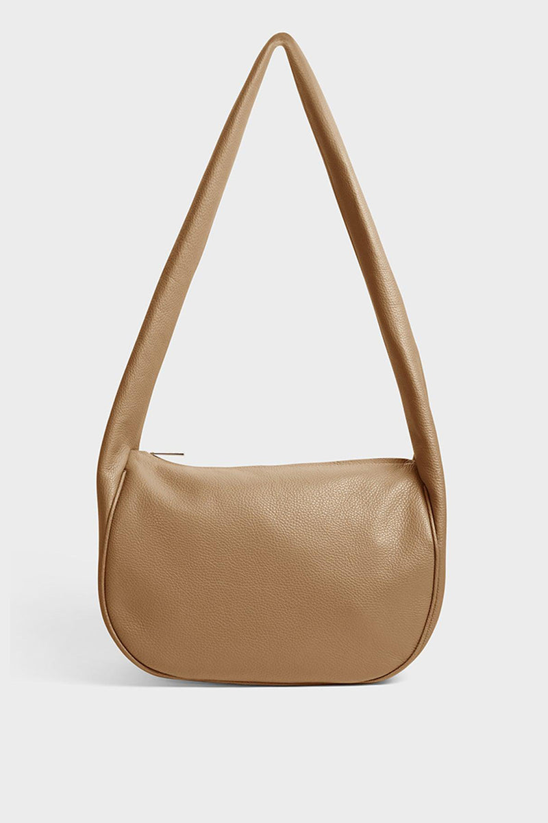 A beige crossbody bag with a hobo satchel-inspired design. It’s made of fine Italian grain leather.