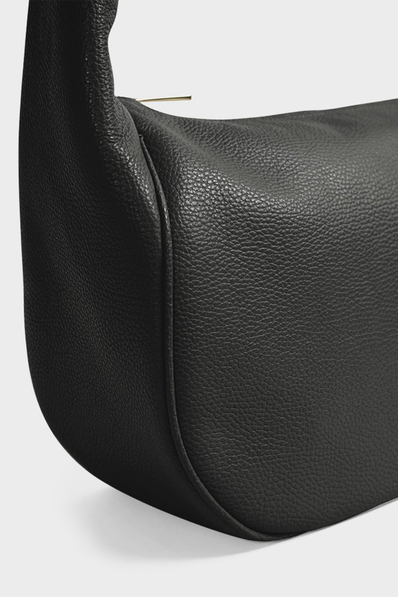 An angled image of the black crossbody bag featuring its large body. The bag is called Halo Day Crossbody Bag in Grain Black