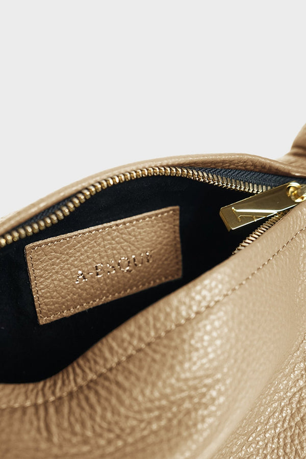 Mini halo bag features gold hardware, suede interior lining, and a durable zipper with the initial “A” engraved for A-esque. 