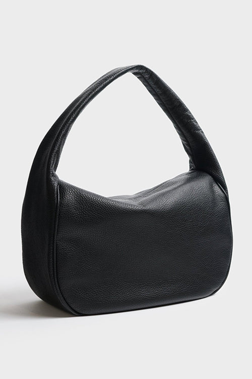 An angled image of halo day shoulder bag. It shows the front of the bag with its fine hand stitching and hobo inspired design and structured body.