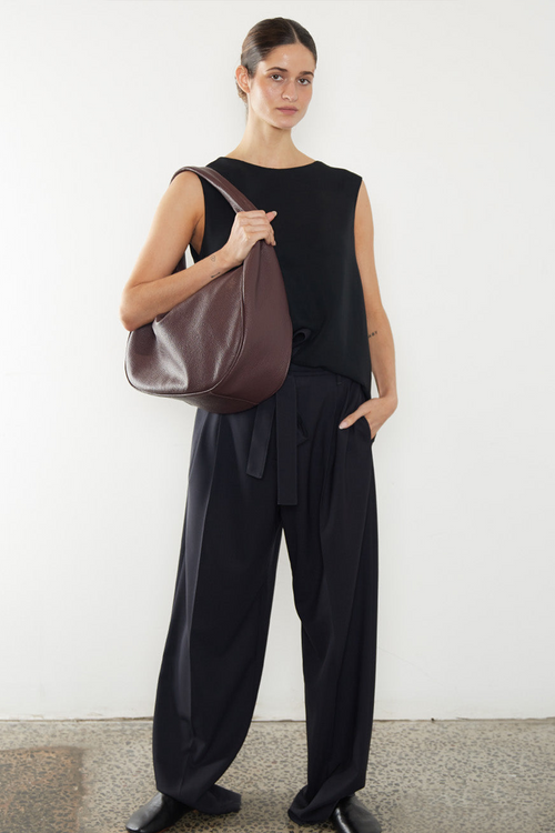 A woman carrying the halo day shoulder bag. The bag is large and great as a day bag.