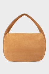 A large suede shoulder bag in the color tan. The handbag has a hobo inspired design.