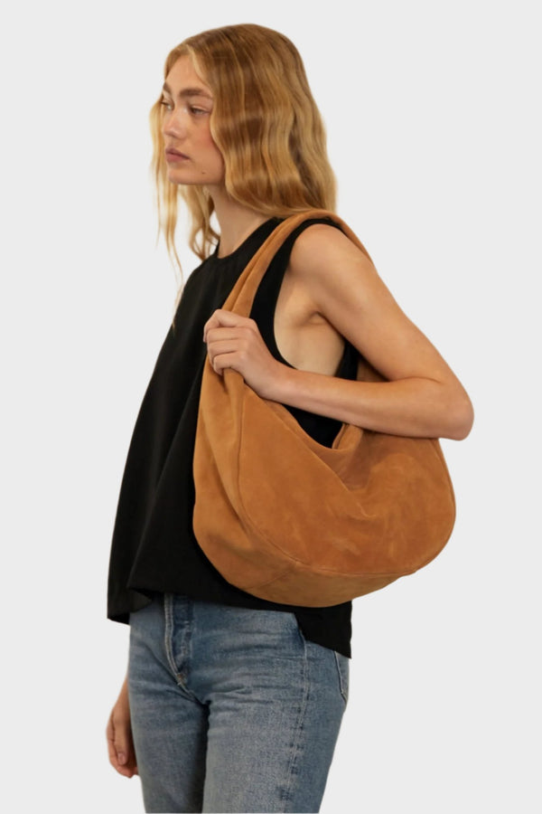 A woman carrying the Halo Day shoulder bag on her shoulder. This handbag suits as a work bag or travel bag.