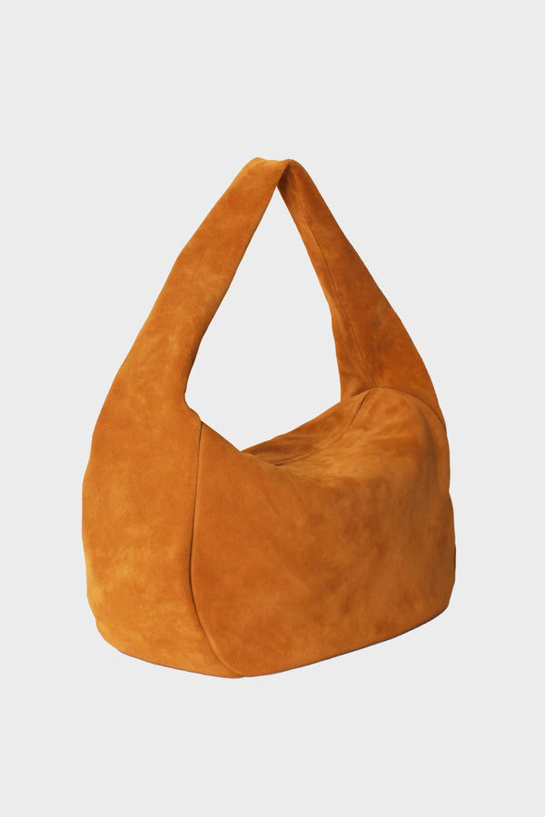 An angled image of halo day suede shoulder bag. It shows the front of the bag with its fine hand stitching, hobo inspired design and structured body.