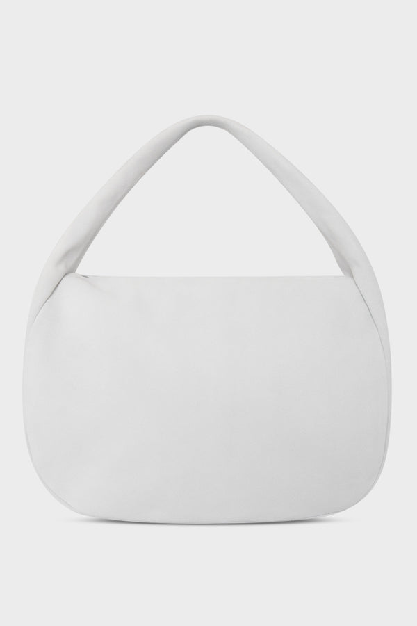 A large suede shoulder bag in the color white. The handbag has a hobo inspired design.