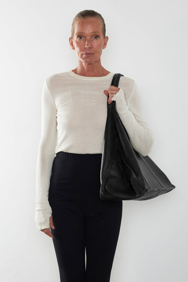 An image of a woman wearing the Jumbo Grocer tote as a shoulder bag. The bag suits as a travel bag.