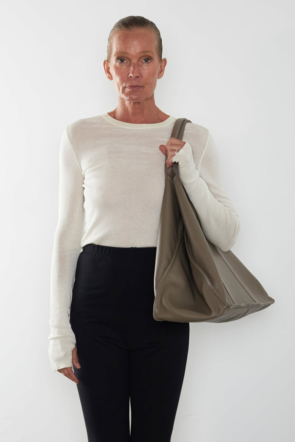 An image of a woman wearing the Jumbo Grocer tote as a shoulder bag. The bag suits as a travel bag.