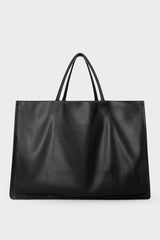 An extra-large black tote bag with a square body. It has an open top with two magnetic closures. The bag has 2 handles to be carried handheld or as a shoulder bag.