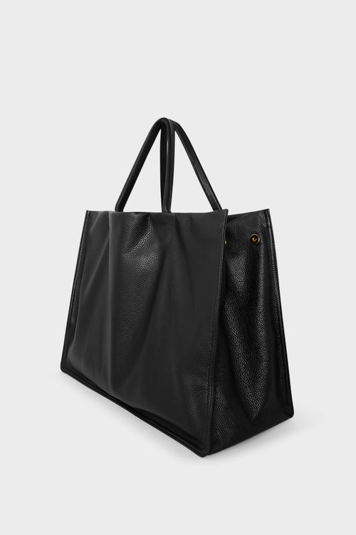 An image of the Jumbo Suite Tote Bag's magnetic closure. With an open-top design, the handbag can be closed through magnets on both sides.