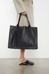 The large grocer tote bag is carried handheld from its handles. This tote bag can also be worn as a shoulder bag.