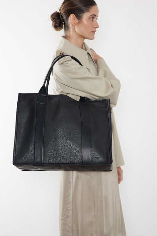 The large Grocer bag is carried as a shoulder bag. This tote can also be worn handheld or on the crook of the arm. It is suited as a work bag.