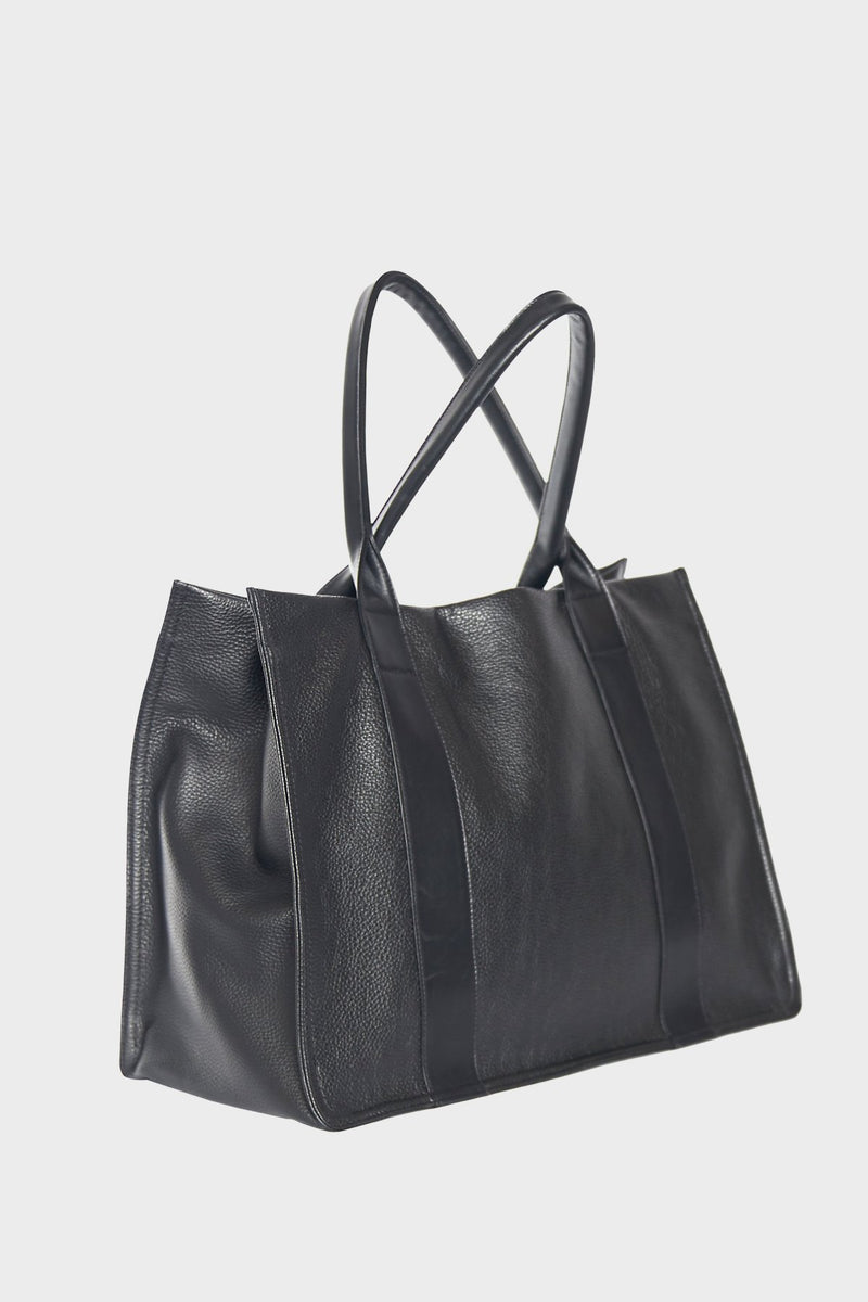 A side image of the Large Grocer black tote bag. Comfortably worn as a shoulder bag or handheld, the bag is suited as an everyday tote.