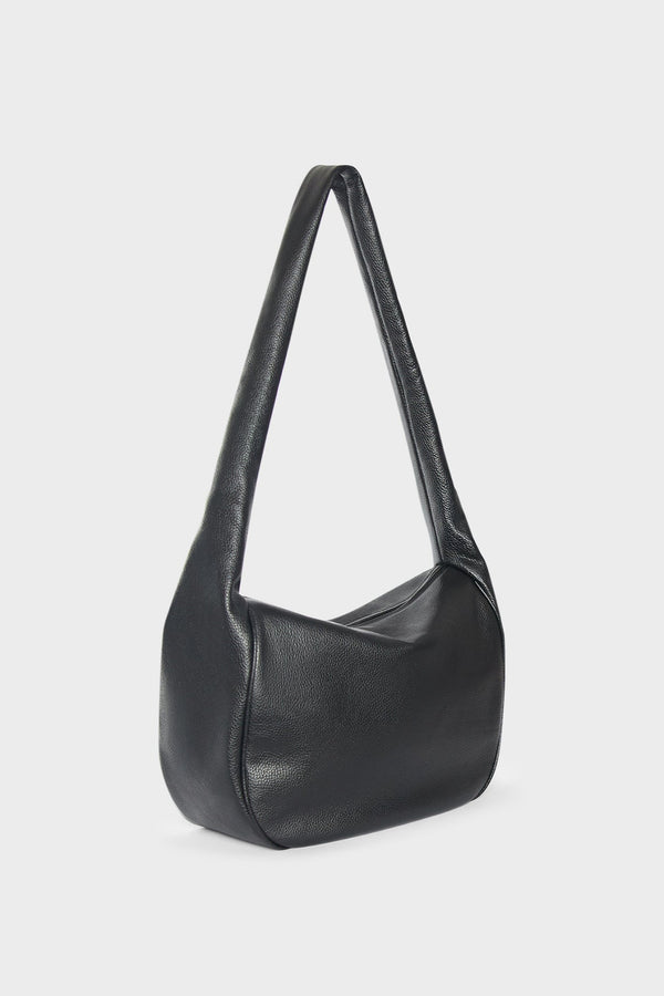 A side image of a crossbody bag that follows a satchel like design. The bag is large and structured.The bag is called Large Halo Crossbody Bag in Grain Black