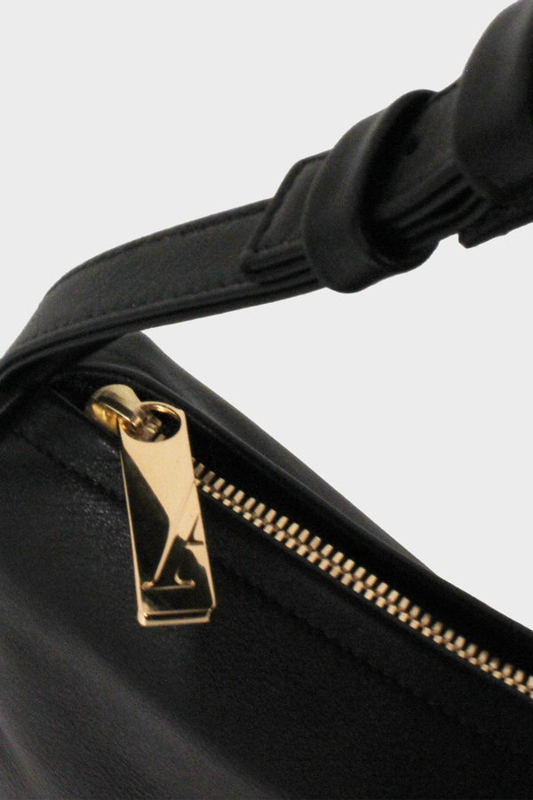 The large saddle shoulder bag features a gold hardware and durable zippers. This image features the satchel's zipper with the initial A which stands for A-esque, the brand's name.