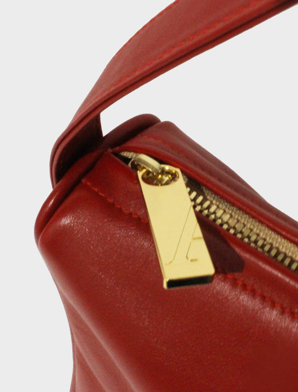 The large saddle shoulder bag features a gold hardware and durable zippers. This image features the satchel's zipper with the initial A which stands for A-esque, the brand's name.