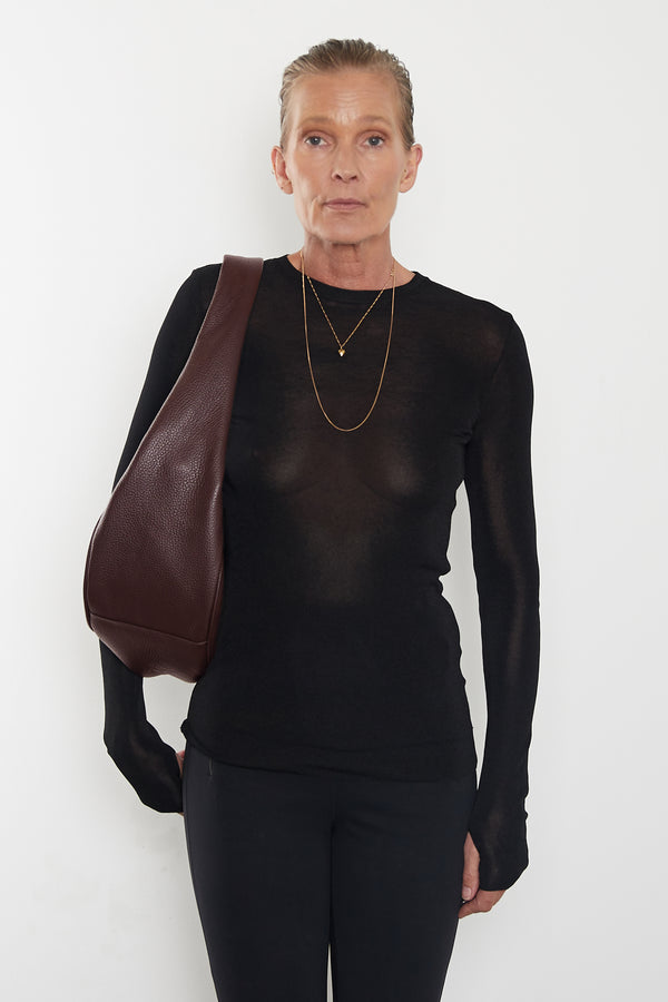 A side image of the Midi Halo day shoulder bag featuring its slightly wide structured body and fine hand stitching. 