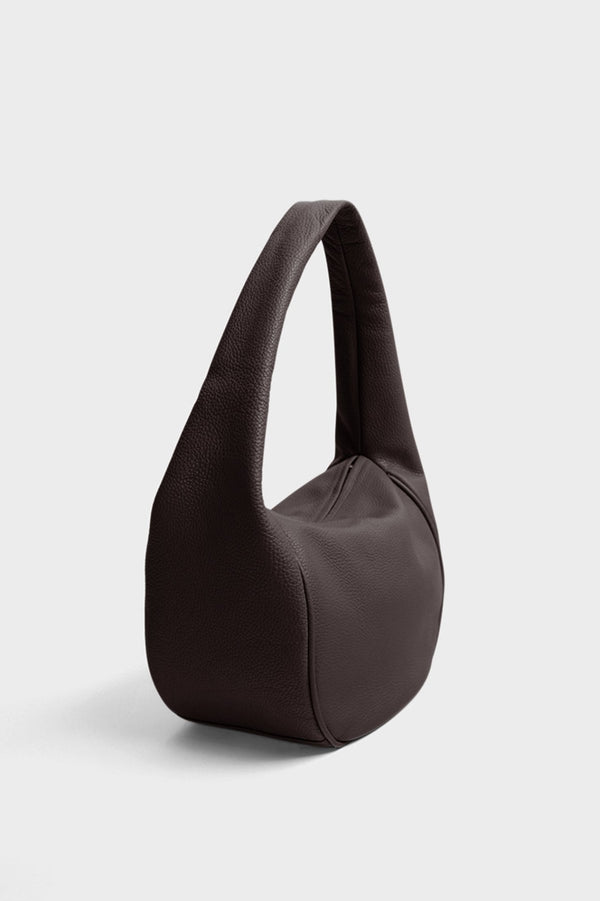 An angled image of Midi Halo Day shoulder bag. It shows the front of the bag with its fine hand stitching and a narrow structured body.