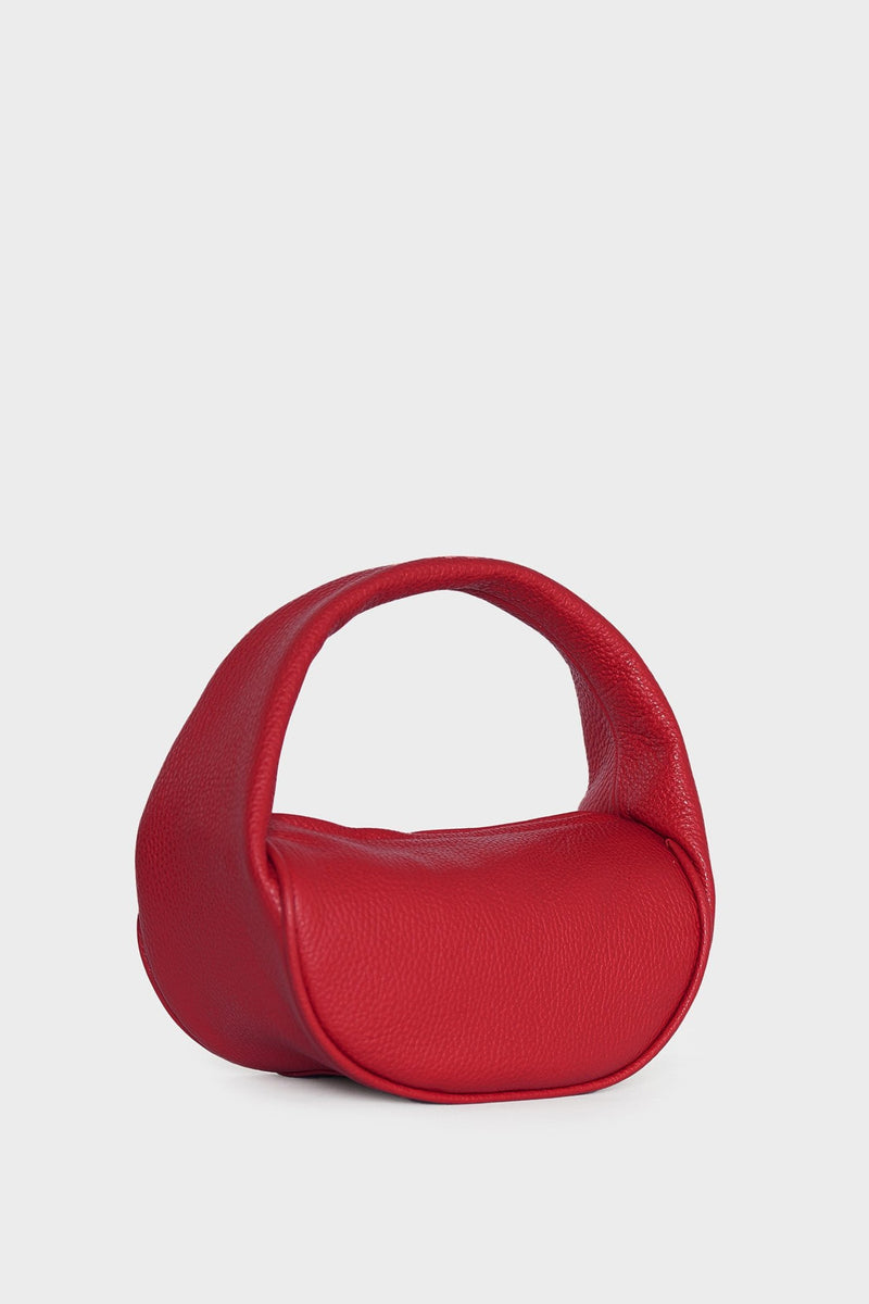 An angled image of the mini bag featuring its U-shaped petite and structured body connected by a single handle to carry as a purse or clutch. 