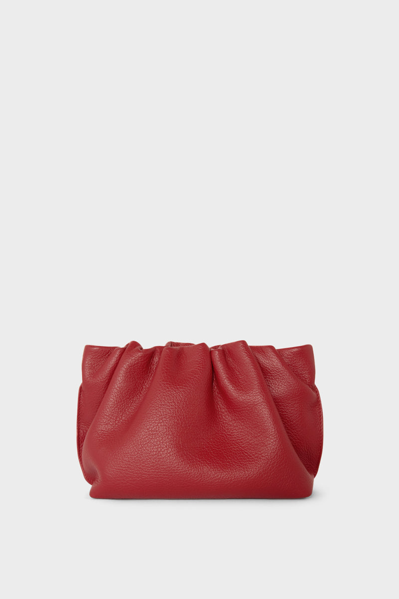 A red mini clutch bag made of smooth Italian leather. This mini bag has a long removable strap and can also be worn as a crossbody bag.