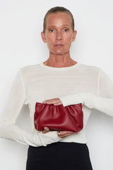 A woman carrying the red mini Puffa clutch bag. This mini bag has a modern design suited as a party clutch purse.