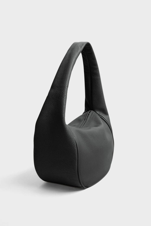 An angled image of Midi Halo Day shoulder bag. It shows the front of the bag with its fine hand stitching and a narrow structured body.